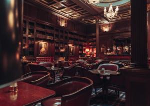 a bar with chairs and tables in a room with books at ProfilHotels Copenhagen Plaza in Copenhagen