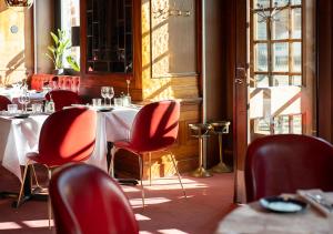 a restaurant with red chairs and tables in a room at ProfilHotels Copenhagen Plaza in Copenhagen