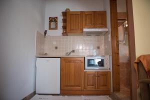 a kitchen with wooden cabinets and a white refrigerator at Traditional Mansion Kliaris in Ayía Kiriakí