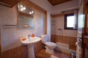 a bathroom with a sink and a toilet and a tub at Traditional Mansion Kliaris in Ayía Kiriakí