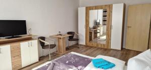 Una sala de estar con un televisor y una mesa y sillas. en RiGa, en Gera