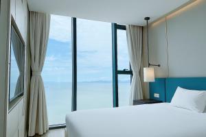a bedroom with a bed and large windows at A La Carte Ha Long Oceanview Fireworksview Panoramic 2BR2WC suite with balcony in Ha Long +67 photos