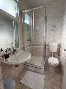 a bathroom with a shower and a sink and a toilet at Rooms Perina Tisno in Tisno +49 photos