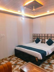 a bedroom with a large bed with blue pillows at Kashi Residency Inn in Varanasi +1 photo