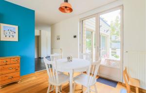 a dining room with a white table and chairs at Belle Villa Proche Plage in Bray-Dunes