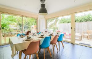 a dining room with a table and chairs and windows at Belle Villa Proche Plage in Bray-Dunes