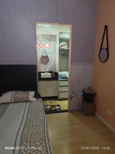 a bedroom with a bed and a door to a closet at Hostel Família Durães in Londrina