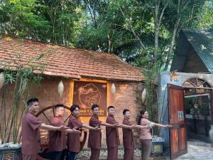 a group of people standing in front of a building at Green Bamboo Lodge Resort in Cat Tien