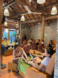 a group of people sitting on beds in a room at Green Bamboo Lodge Resort in Cat Tien