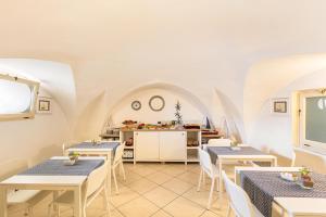 ガリポリにあるB&B Palazzo Vergineのテーブルと椅子とキッチンのあるレストラン