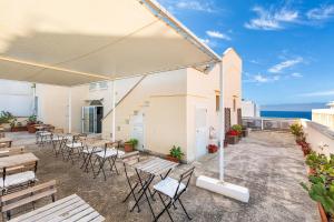 ガリポリにあるB&B Palazzo Vergineの椅子とテーブルと傘のあるパティオ