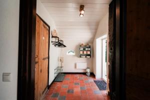 a hallway with a door and a tile floor at De Daler Deel in Dalen