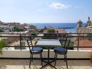 a table and chairs on a balcony with a view of the ocean at Vers Les Nuages Apartment, Old Souk, Sea View in Batroûn