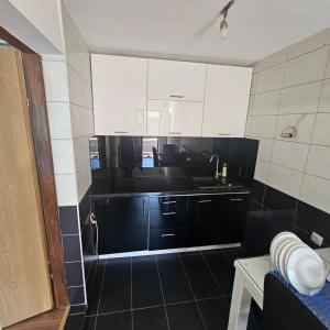 a kitchen with black and white cabinets and a sink at Apartment Savanovic in Banja Luka +54 photos