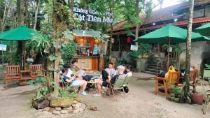 a group of people sitting at a table outside a restaurant at Green Bamboo Lodge Resort in Cat Tien