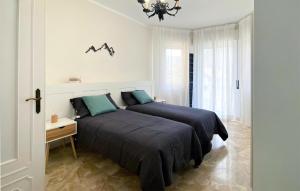 a bedroom with two beds and a chandelier at 2 Bedroom Cozy Apartment In Montoggio in Montoggio