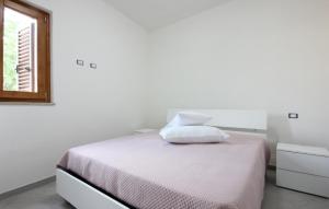 a white bedroom with a bed and a window at Gorgeous Home In Casalvelino With Wifi in Casal Velino