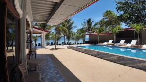 a swimming pool with chairs and a table next to a house at Lawson’s Beach Resort in San Juan