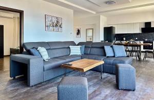 a living room with a blue couch and a table at Thea Penthouse with private parking in Sarandë