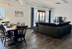 a living room with a table and a couch at Thea Penthouse with private parking in Sarandë