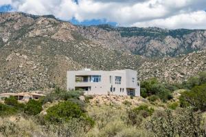 a white house in the middle of a mountain at Luxury 4BR Retreat with Mountain views in Sandia Park