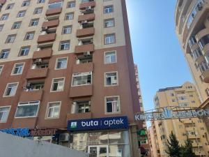 a tall building with a sign in front of it at Kvartira s vidom na more in Sumqayıt