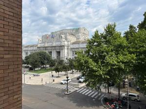 un grande edificio bianco con le auto parcheggiate di fronte di AV Hotel Milano a Milano
