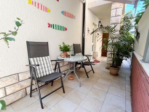 a patio with chairs and a table on a wall at Studio Izola in Izola