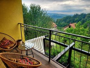 a balcony with two chairs and a table and a view at Sunny House in Banja Koviljača