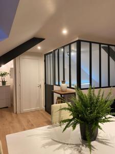 a living room with a couch and a table with a plant at Appartement Atypique- Esprit Atelier Loft - parking privé - Wifi - vidéo in Amiens