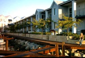 a woman standing next to a river with houses at Waterfront Hideaway with Pool, Spa & BBQ Area jetty available in Mandurah