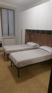 two beds sitting in a room withermottermott at Casa vacanze Vittoria in Caprarola