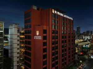 een hoog rood gebouw met een bord erop bij 广州白云站新市骑士物语酒店 in Guangzhou
