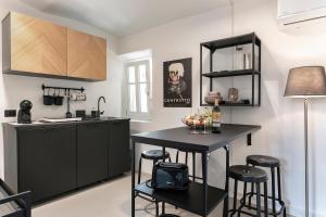 a kitchen with a black island with bar stools at Grapeful Stay - Canelli center - 8 pax - free park in Canelli