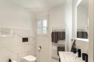 a white bathroom with a toilet and a sink at Grapeful Stay - Canelli center - 8 pax - free park in Canelli
