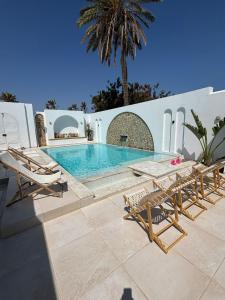 米多恩Houch Saramina的一个带椅子和桌子的游泳池以及棕榈树
