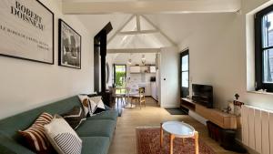 a living room with a green couch and a table at Hozanna chic & charme in Le Crotoy
