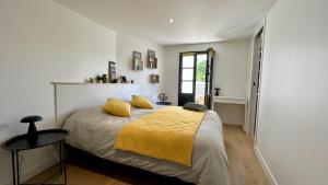 a bedroom with a bed with a yellow blanket at Hozanna chic & charme in Le Crotoy