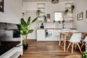 une cuisine avec des armoires blanches et une table avec une plante en pot dans l'établissement Castrelli Loft Rho-Fiera Milano, à Rho