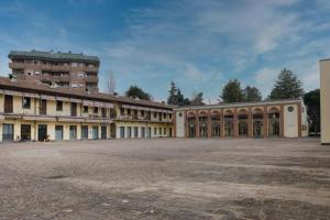 un vieux bâtiment avec de nombreuses fenêtres dans une cour dans l'établissement Castrelli Loft Rho-Fiera Milano, à Rho
