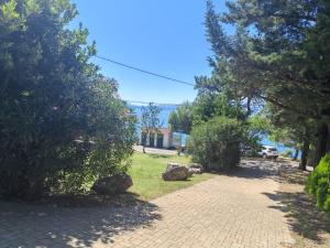 a brick walkway with trees and a car on a street at Apartment Del Mar in Novi Vinodolski