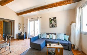 ein Wohnzimmer mit einem blauen Sofa und einem Tisch in der Unterkunft Amazing Home In St André De Roqueper in Montclus