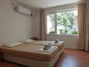 a bedroom with a bed and a large window at Studio Garden City Center Pomorie in Pomorie