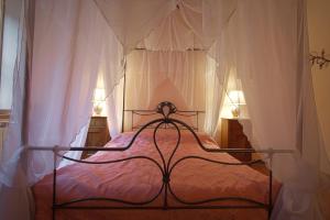 - une chambre avec un lit à baldaquin et une couette rose dans l'établissement Il Gattopardo, à Cividale del Friuli