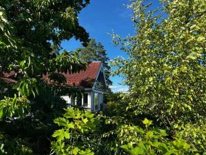 a small house surrounded by trees and blue sky at Son view in Vestby