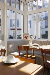 a restaurant with a table and chairs and windows at Alfred Hotels Les Halles in Biarritz