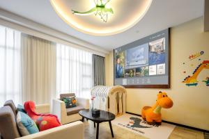 Mehood Theater Hotel, Changzhou Dinosaur Park في تشانغتشو: غرفة معيشة مع غرفة أطفال مع سرير أطفال