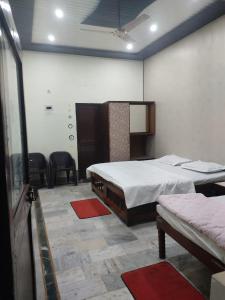 a room with two beds and chairs in it at Hotel Fort View Orchha in Orchha