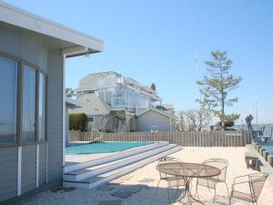 a patio with a table and chairs next to a pool at Bay Front Home In Loveladies, in Loveladies