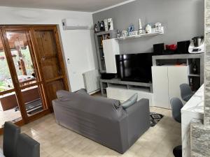 a living room with a couch and a television at Silvana Home in Marina di Sorso